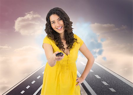 Composite image of smiling curly haired pretty woman changing channel with remote Stock Photo - Budget Royalty-Free & Subscription, Code: 400-07187532