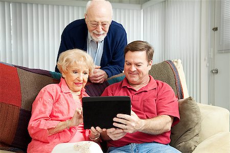 Adult son teaching his parents to use their new tablet pc. Stock Photo - Budget Royalty-Free & Subscription, Code: 400-07180010