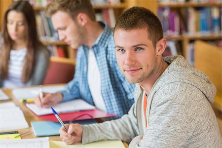 simsearch:400-07180633,k - Group portrait of students writing notes at desk in the college library Foto de stock - Super Valor sin royalties y Suscripción, Código: 400-07180649