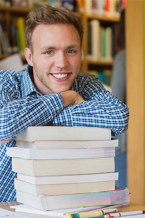 Close up portrait of a smiling male student with stack of books at the college library Stock Photo - Budget Royalty-Free & Subscription, Code: 400-07180669