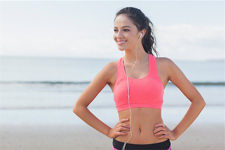 simsearch:400-07180905,k - Beautiful smiling healthy woman with earphones standing on beach Photographie de stock - Aubaine LD & Abonnement, Code: 400-07180901