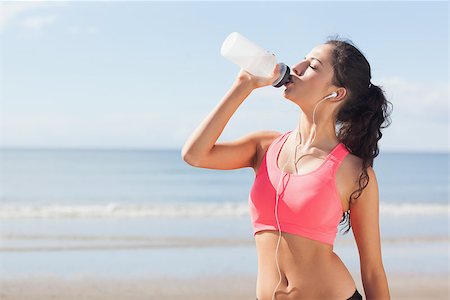 simsearch:400-07180905,k - Beautiful healthy woman with earphones drinking water on beach Photographie de stock - Aubaine LD & Abonnement, Code: 400-07180902