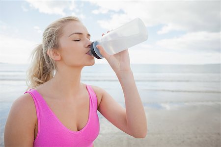 simsearch:400-07180905,k - Beautiful healthy woman in pink sports bra drinking water on beach Photographie de stock - Aubaine LD & Abonnement, Code: 400-07180919