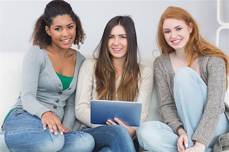 simsearch:400-07181183,k - Portrait of young female friends using digital tablet together on sofa at home Photographie de stock - Aubaine LD & Abonnement, Code: 400-07181098