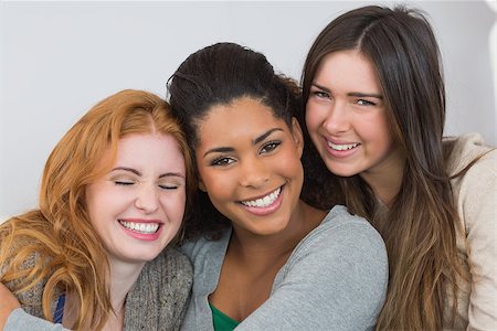 simsearch:400-07181183,k - Close up portrait of cheerful young female friends on sofa at home Photographie de stock - Aubaine LD & Abonnement, Code: 400-07181118