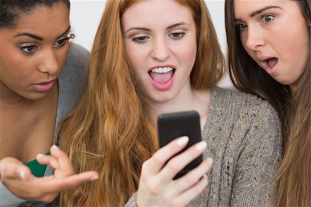 simsearch:400-07181183,k - Close up of shocked young female friends looking at mobile phone together at home Photographie de stock - Aubaine LD & Abonnement, Code: 400-07181130