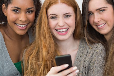 simsearch:400-07181183,k - Close up portrait of cheerful young female friends with mobile phone together at home Photographie de stock - Aubaine LD & Abonnement, Code: 400-07181132