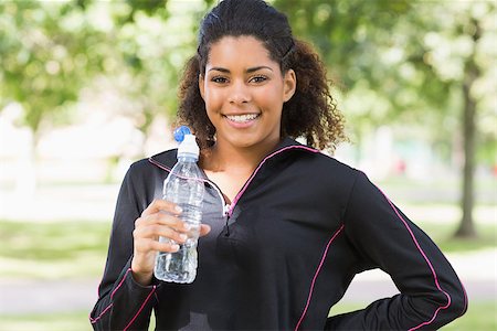 Portrait of a smiling healthy young woman with water bottle in the park Stock Photo - Budget Royalty-Free & Subscription, Code: 400-07181204