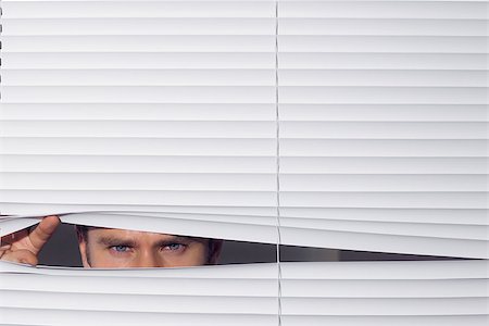 peeping through - Close up portrait of a young businessman peeking through blinds Stock Photo - Budget Royalty-Free & Subscription, Code: 400-07181515