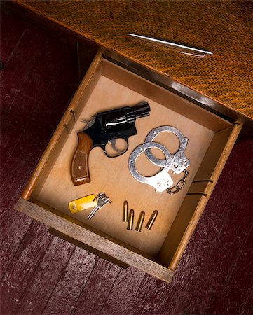 A desk housing pen, a key, ammunition, and handcuffs Stock Photo - Budget Royalty-Free & Subscription, Code: 400-07207480