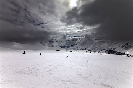 simsearch:400-08780271,k - Ski slope, skiers and sky with storm clouds. Georgia, ski resort Gudauri. Caucasus Mountains. Wide angle view. Photographie de stock - Aubaine LD & Abonnement, Code: 400-07215521