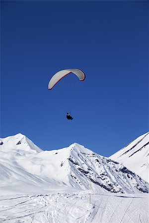 paragliding extreme sport - Paraglider in sunny snowy mountains. Caucasus Mountains. Georgia, ski resort Gudauri. Stock Photo - Budget Royalty-Free & Subscription, Code: 400-07217919