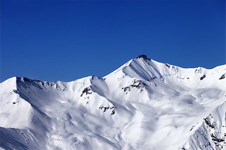simsearch:400-07222348,k - Off-piste snowy slope and blue clear sky. Caucasus Mountains, Georgia, ski resort Gudauri. Fotografie stock - Microstock e Abbonamento, Codice: 400-07219034