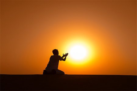 Man silhouette kneel and pray for help with gold sunset sun on background Stock Photo - Budget Royalty-Free & Subscription, Code: 400-07210142