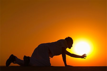 person on all four - Tired and weaken man on all fours reached his hand to gold sunset sun disk to pray for help Stock Photo - Budget Royalty-Free & Subscription, Code: 400-07210143