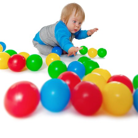 Comical child playing with colored plastic balls on white floor Photographie de stock - Aubaine LD & Abonnement, Code: 400-07210481
