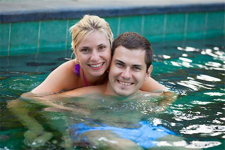 Happy smiling young couple relaxing in a swimming pool in tropical resort Stock Photo - Budget Royalty-Free & Subscription, Code: 400-07210659