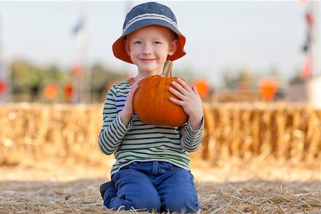 simsearch:400-07793720,k - adorable smiling boy holding pumpkin at the pumpkin patch Photographie de stock - Aubaine LD & Abonnement, Code: 400-07211172