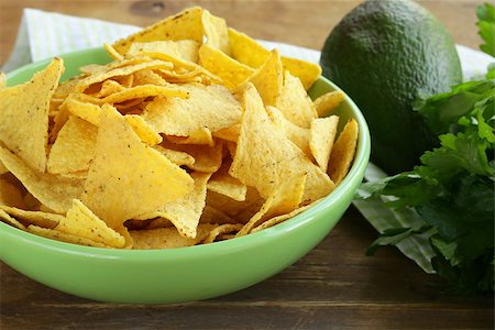 corn chips (nachos) in a green bowl on wooden table Stock Photo - Budget Royalty-Free & Subscription, Code: 400-07213403