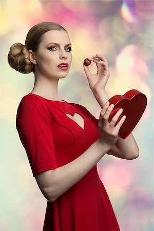 simsearch:400-07218439,k - portrait of attractive young girl with pretty hair-style and make-up wearing red dress and taking in the hand her valentine  gift, one box of chocolates Foto de stock - Super Valor sin royalties y Suscripción, Código: 400-07224148