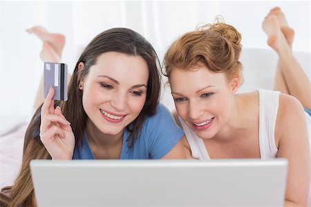 simsearch:6109-06194946,k - Happy relaxed young female friends  doing online shopping through laptop and credit card in bed Fotografie stock - Microstock e Abbonamento, Codice: 400-07228026