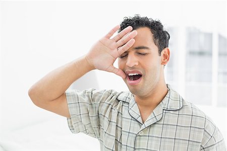 simsearch:640-06051691,k - Close-up of a young man sitting and yawning in bed at home Stockbilder - Microstock & Abonnement, Bildnummer: 400-07228375