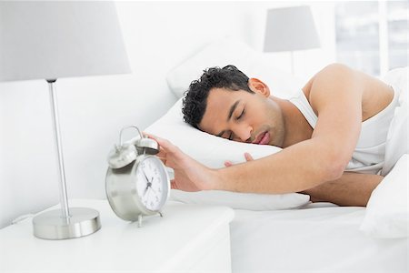 simsearch:614-02613098,k - Sleepy young man in bed extending hand to alarm clock Stockbilder - Microstock & Abonnement, Bildnummer: 400-07228408