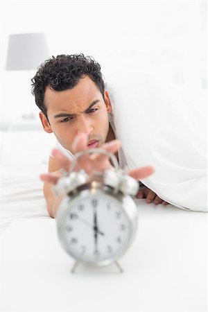 simsearch:614-02613098,k - Close-up of a sleepy young man in bed extending hand to alarm clock at home Stockbilder - Microstock & Abonnement, Bildnummer: 400-07228418