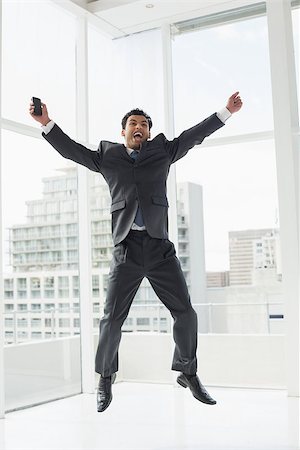 Full length of a cheerful elegant young businessman cheering in a bright office Stock Photo - Budget Royalty-Free & Subscription, Code: 400-07228445