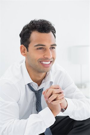 sophisticated home smile - Close-up of a happy young businessman sitting on bed at home Stock Photo - Budget Royalty-Free & Subscription, Code: 400-07228479