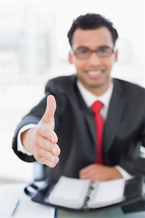 Portrait of an elegant blurred businessman offering a handshake at office desk Stock Photo - Budget Royalty-Free & Subscription, Code: 400-07228534