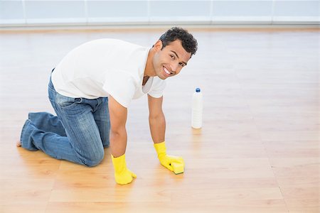simsearch:400-04214184,k - Side view portrait a smiling young man cleaning the parquet floor at house Stockbilder - Microstock & Abonnement, Bildnummer: 400-07228655