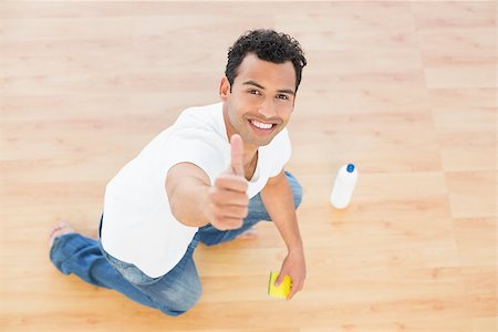 simsearch:400-04214184,k - Portrait of a smiling young man cleaning the floor while gesturing thumbs up at house Stockbilder - Microstock & Abonnement, Bildnummer: 400-07228651