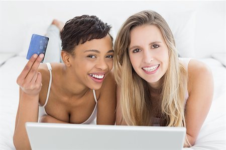 simsearch:6109-06194946,k - Portrait of happy relaxed young female friends doing online shopping through laptop and credit card in bed Fotografie stock - Microstock e Abbonamento, Codice: 400-07228798