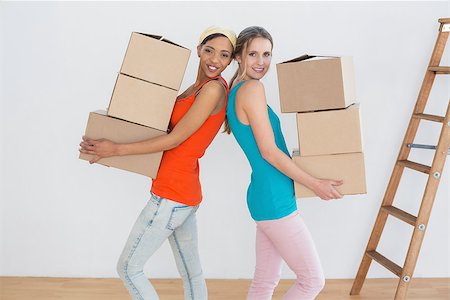 Side view portrait of two female friends moving together in a new house Stock Photo - Budget Royalty-Free & Subscription, Code: 400-07229096