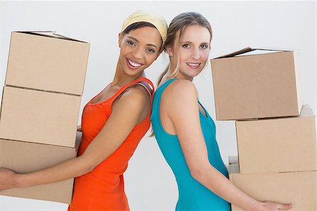 Side view portrait of two female friends moving together in a new house Stock Photo - Budget Royalty-Free & Subscription, Code: 400-07229097