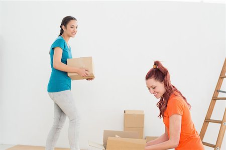Two friends moving together in a new house and unwrapping boxes Stock Photo - Budget Royalty-Free & Subscription, Code: 400-07229371