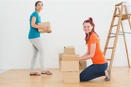 Portrait of two friends moving together in a new house and unwrapping boxes Stock Photo - Budget Royalty-Free & Subscription, Code: 400-07229372