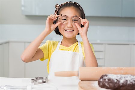 Portrait of a smiling young girl holding cookie molds in the kitchen at home Stock Photo - Budget Royalty-Free & Subscription, Code: 400-07229757