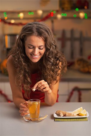 Happy young woman putting brown sugar cube into ginger tea Stock Photo - Budget Royalty-Free & Subscription, Code: 400-07221417