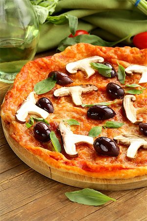 simsearch:400-04539943,k - Italian pizza with olives and mushrooms on a wooden board Stockbilder - Microstock & Abonnement, Bildnummer: 400-07221413