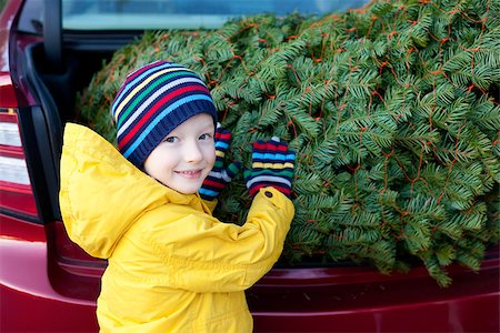 cheerful little boy holding christmas tree Photographie de stock - Aubaine LD & Abonnement, Code: 400-07222617