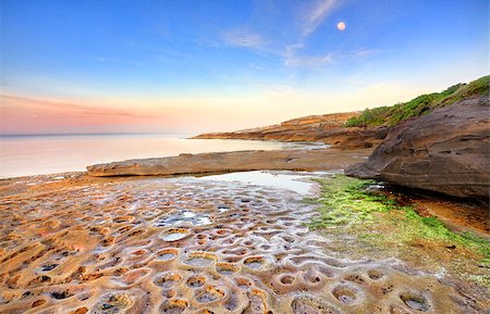 simsearch:400-07667033,k - Sunrise at Botany Bay, La Perouse, Sydney Australia on a calm summers morning, the moon still shining overhead  of the strange moonscape crater like potholes in the rocks below. Stock Photo - Budget Royalty-Free & Subscription, Code: 400-07223795