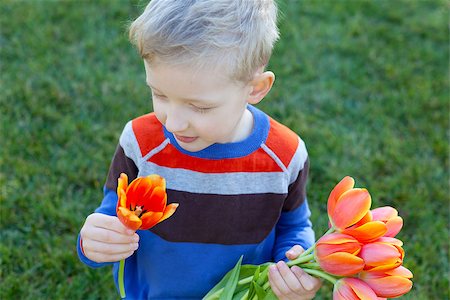 simsearch:400-06768635,k - positive smiling boy holding beautiful flowers at spring time Foto de stock - Royalty-Free Super Valor e Assinatura, Número: 400-07223948