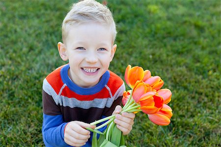 simsearch:400-06768635,k - positive smiling boy holding beautiful flowers at spring time Foto de stock - Royalty-Free Super Valor e Assinatura, Número: 400-07223943