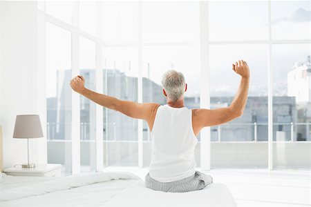 Rear view of a mature man waking up in bed and stretching his arms Stock Photo - Budget Royalty-Free & Subscription, Code: 400-07230602