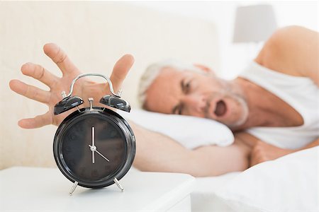 simsearch:614-02613098,k - Blurred mature man extending hand to alarm clock in bed at home Stockbilder - Microstock & Abonnement, Bildnummer: 400-07230654