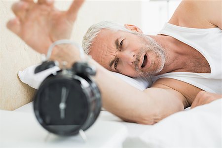 simsearch:614-02613098,k - Sleepy mature man extending hand to alarm clock in bed at home Stockbilder - Microstock & Abonnement, Bildnummer: 400-07230656