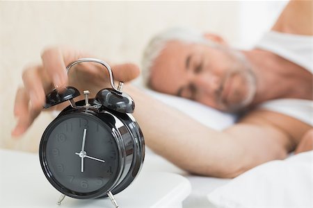 simsearch:614-02613098,k - Sleepy mature man extending hand to alarm clock in bed at home Stockbilder - Microstock & Abonnement, Bildnummer: 400-07230658