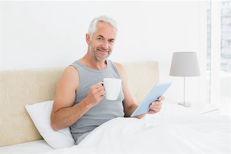 simsearch:400-07230809,k - Portrait of a smiling mature man with digital tablet and coffee table sitting in bed at home Foto de stock - Super Valor sin royalties y Suscripción, Código: 400-07230666